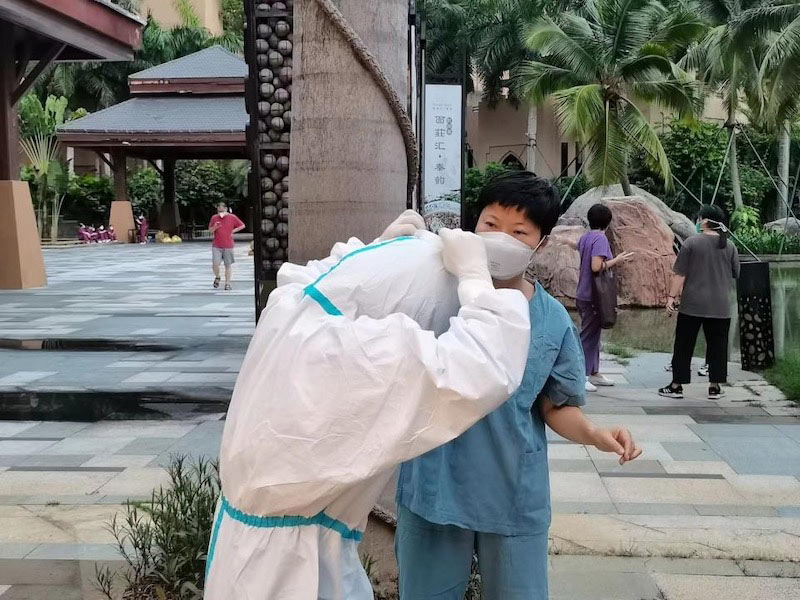 張翔幫助同事整理防護(hù)服。受訪者供圖