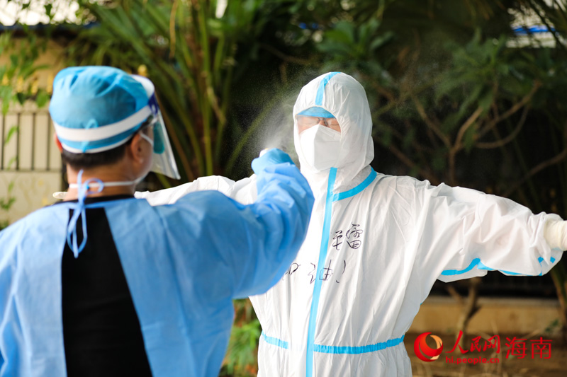協助醫護人員做核酸后，記者對全身進行消殺。人民網 符武平攝