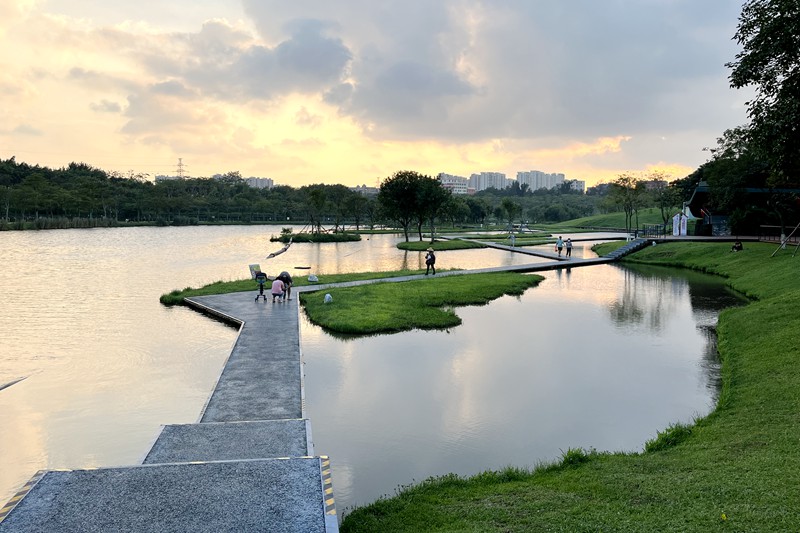 海口瓊山區(qū)美舍河鳳翔濕地公園一隅，市民在親水步道享受落日余暉下的天光水色。