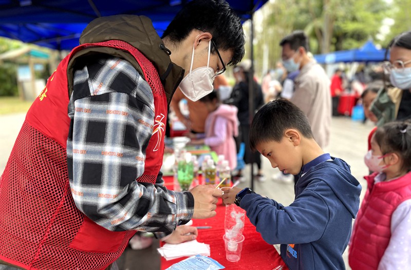 2023年世界濕地日主題游園宣傳活動(dòng)現(xiàn)場(chǎng)，志愿者與小朋友共同模擬濕地在自然中凈化水質(zhì)的過程。