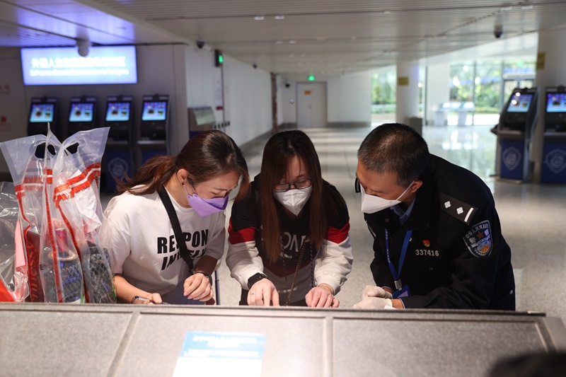 海口美蘭邊檢站民警正在指導入境旅客填寫外國人登記卡。朱晨鵬攝