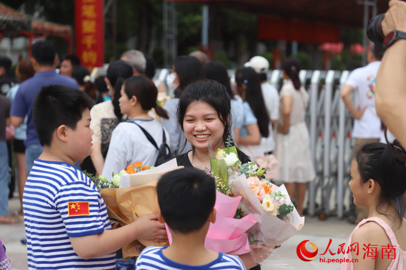 小朋友們手捧鮮花迎接姐姐。人民網 牛良玉攝