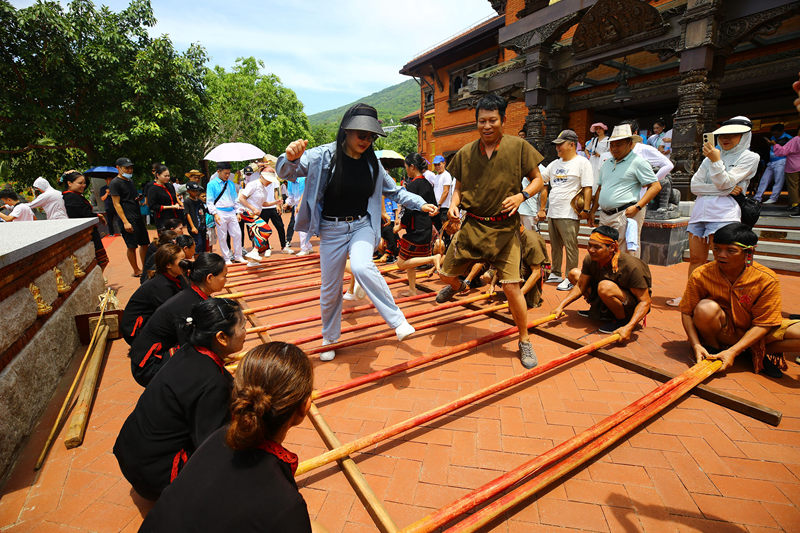 6月10日，三亞南山非遺節現場，游客體驗國家非遺項目《打柴舞》。陳文武攝