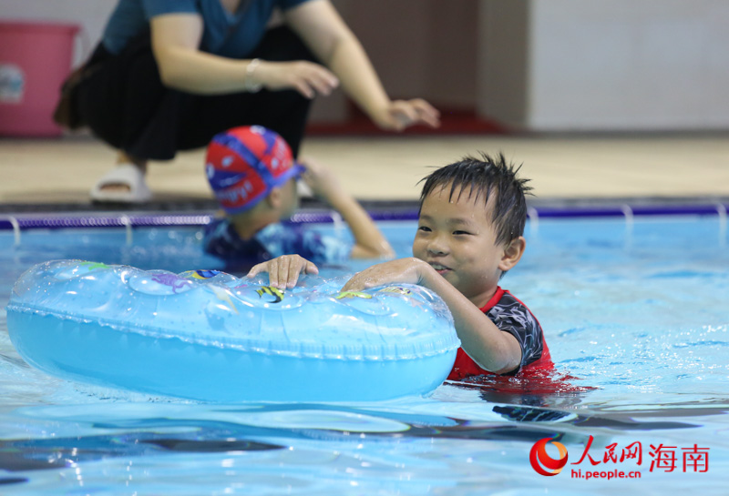 在三亞市吉陽區丹州小學游泳館內，一名學生正借助泳圈學習游泳。人民網 牛良玉攝