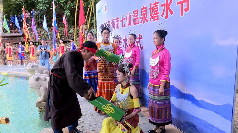 “長老”從圣水潭中舀起象征吉祥如意的“圣水”裝滿竹筒。保亭縣委宣傳部供圖