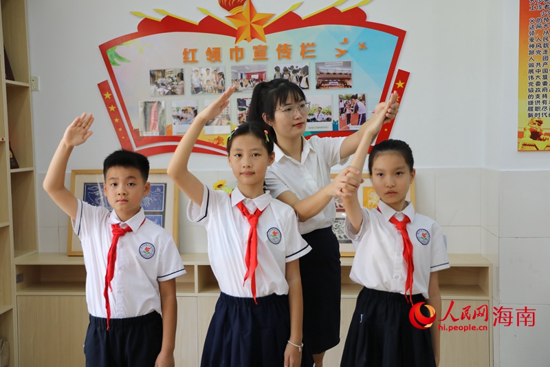 黃雨媚老師糾正同學行中國少年先鋒隊隊禮的姿勢。 人民網(wǎng)記者 孟凡盛攝