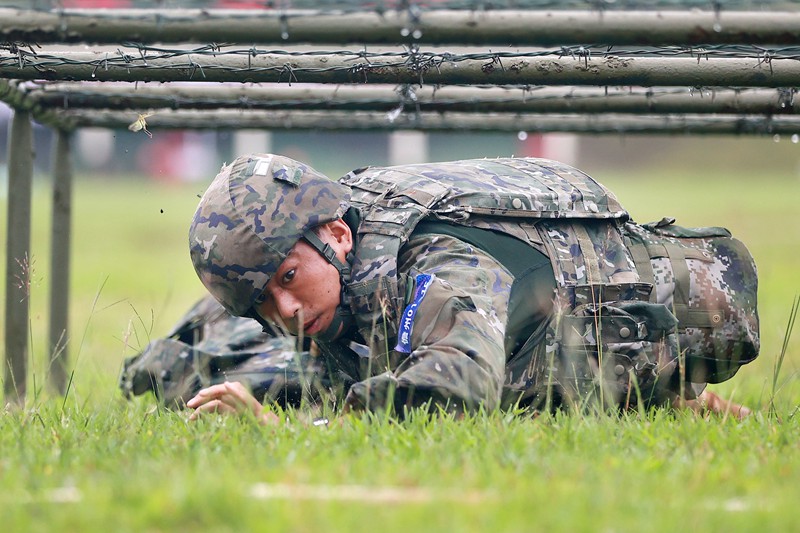 參賽官兵全副武裝通過低樁網。武警海南總隊供圖