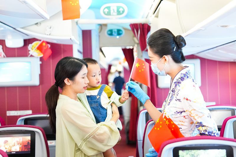 10月1日，海南航空乘務(wù)員為機(jī)上旅客發(fā)放小國(guó)旗。海南航空供圖.jpg