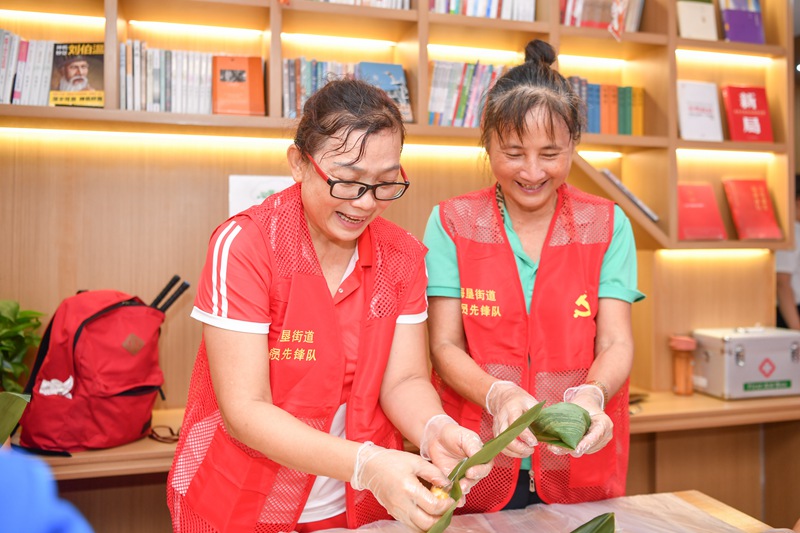 6月20日，在海口龍華區海墾街道華墾社區，社區居民一起體驗包粽子。海口市委宣傳部供圖