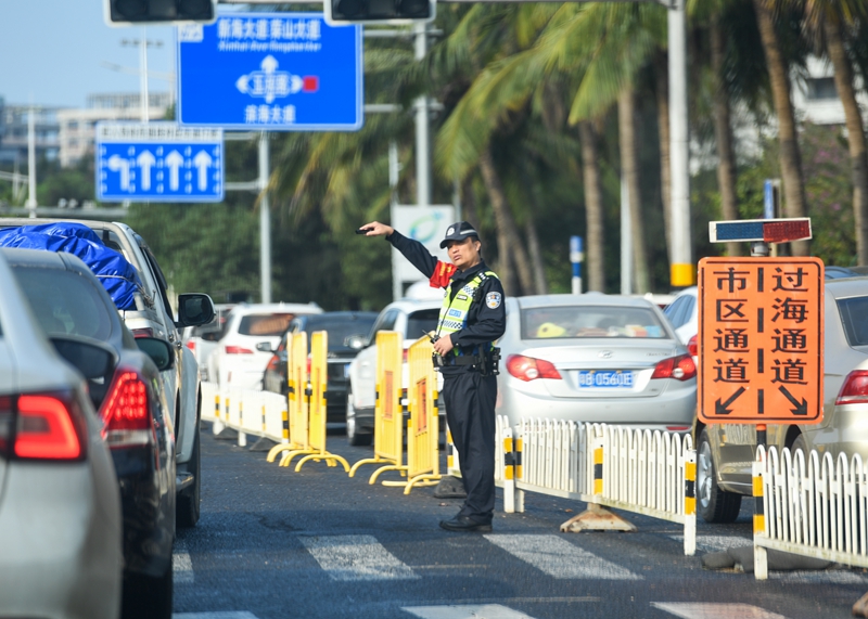 海口市濱海大道交警正在指引過(guò)海車(chē)輛有序通行前往新海港碼頭。石中華攝