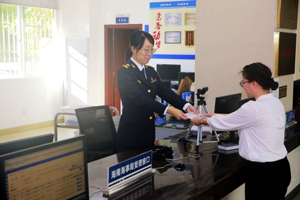 海南海事局政務(wù)中心工作人員頒發(fā)海南省首批遠洋漁業(yè)船員海員證。汪蓓攝