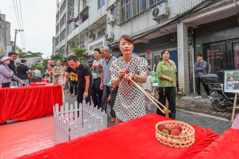 現(xiàn)場設置的“長筷夾荔枝”挑戰(zhàn)，緊張有趣。  主辦方供圖