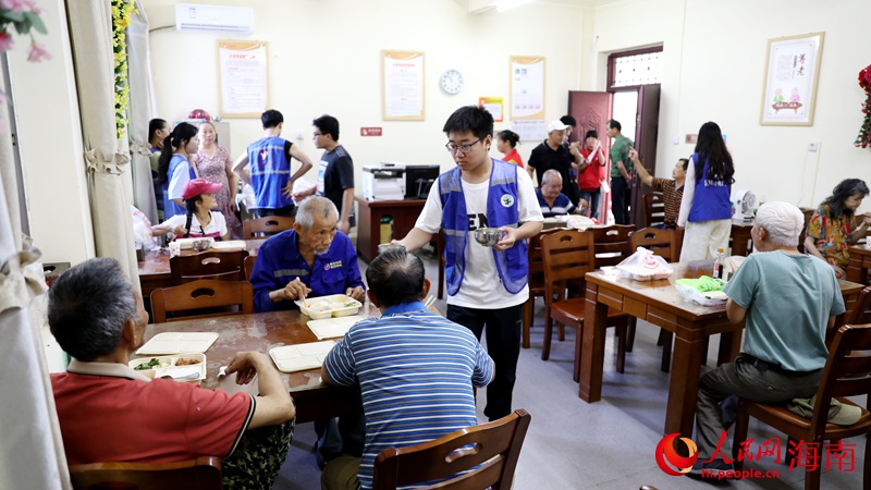 志愿者正在給用餐的老人盛湯。人民網記者 符武平攝