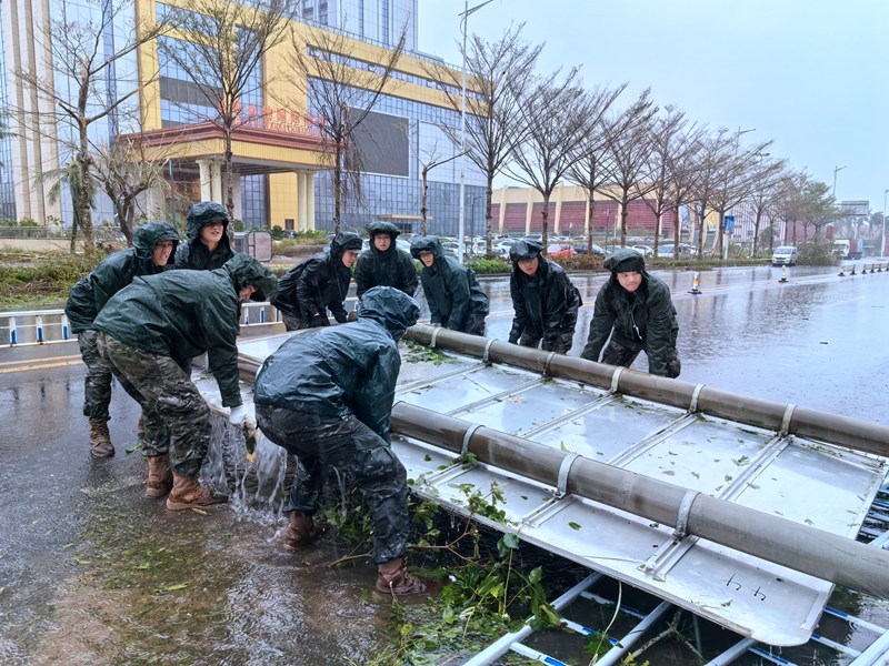 武警海口支隊官兵正在移除被風吹到的路邊指示牌。房立攝