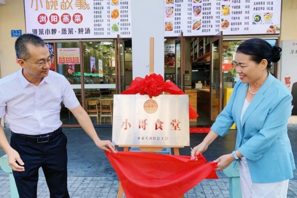 三亞市總工會黨組副書記、常務副主席周月霞（右）為三亞市首批工會小哥食堂揭牌。天涯區總工會供圖