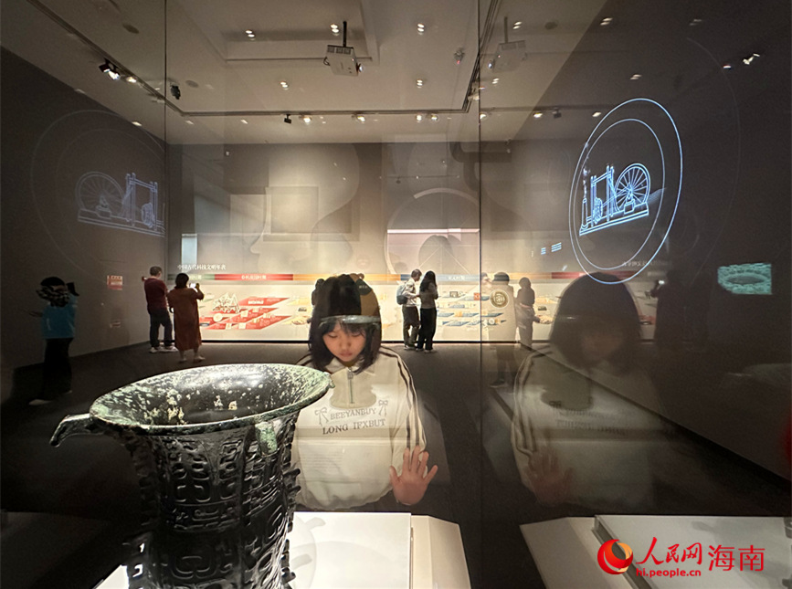 觀眾在海南省博物館內(nèi)駐足欣賞“譬若天工——中國(guó)古代文物中的科技奧秘”展出的文物。人民網(wǎng) 劉楊攝