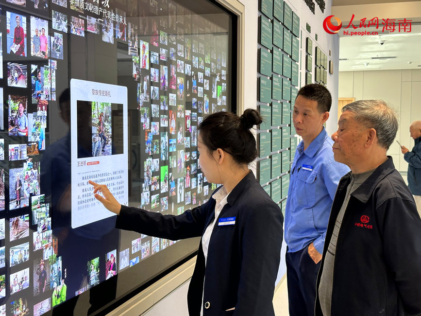 海南省文化館的工作人員向游客展示海南省省級非物質文化遺產代表性項目的相關內容。人民網 劉楊攝