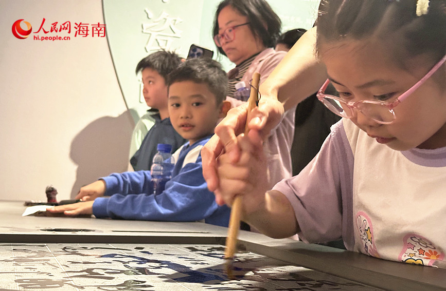 在“文明載體——古代造紙印刷”單元，雕版印刷互動裝置吸引孩子們躍躍欲試。人民網 劉楊攝