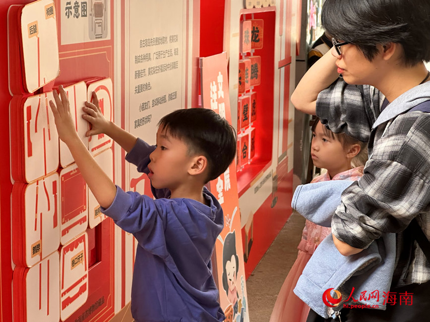 一名小朋友及其家人在海南省博物館舉辦的主題科普互動展中體驗“闖關”游戲。人民網 劉楊攝