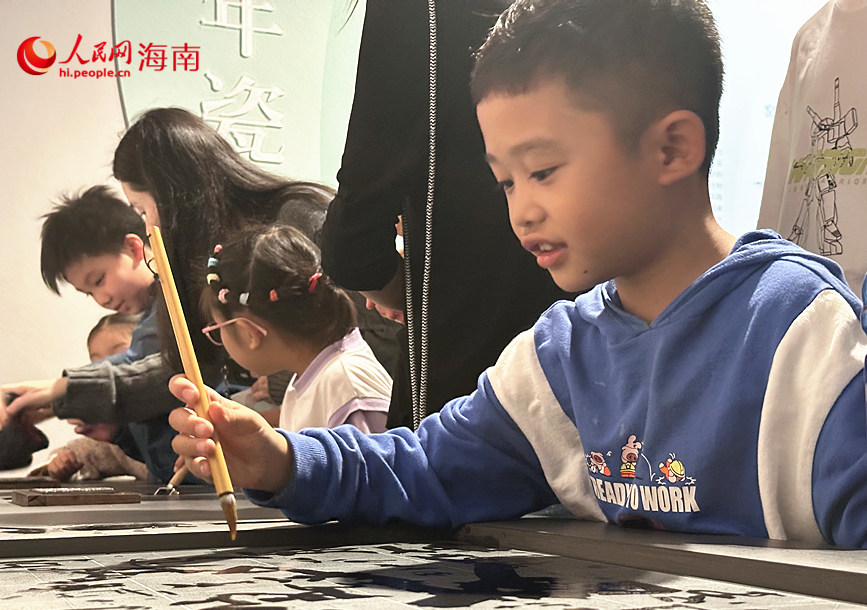 小朋友在“文明載體——古代造紙印刷”單元體驗雕版印刷互動裝置。人民網 劉楊攝