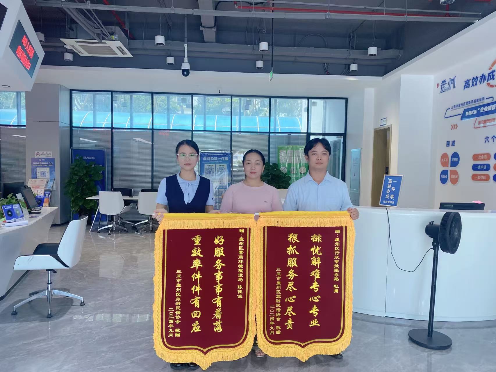 三亞市崖州區旅游民宿協會代表周女士將兩面錦旗送到了崖州區政務服務中心。崖州區營商環境局供圖