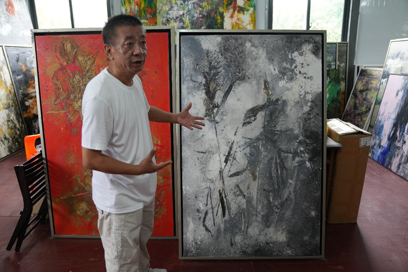 朱鯤向媒體記者介紹自己的作品。主辦方供圖