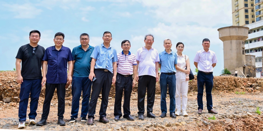 考察組在老城鎮通潮驛原址合影留念，腳下石層平面是考古專家勘探發掘出的古代石鋪驛道，右側水塔位置是經多方面專家考證的通潮閣遺址。